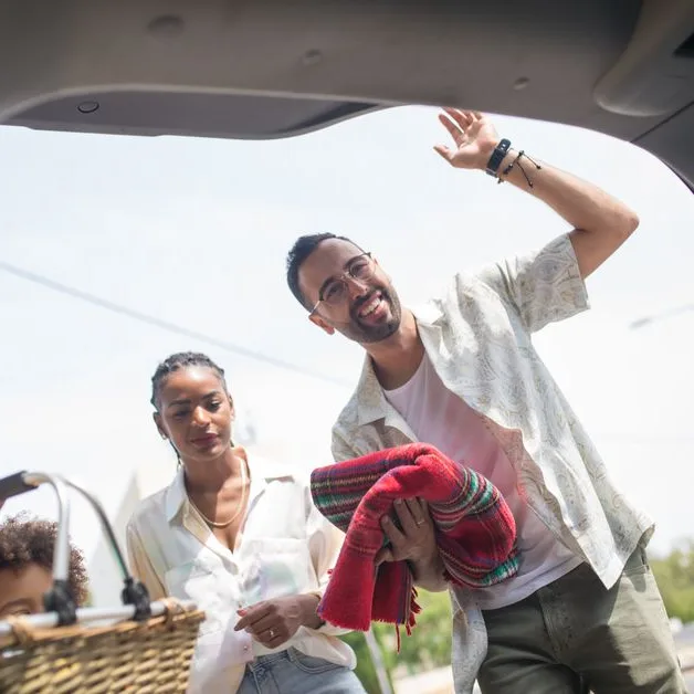 Famille qui charge le coffre avant un départ